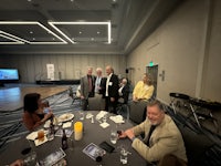 a group of people sitting around a table in a conference room