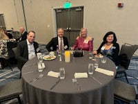 a group of people sitting at a table in a conference room