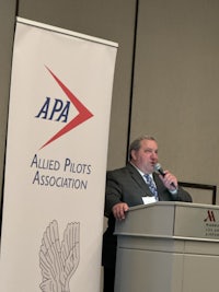 a man in a suit standing in front of a podium