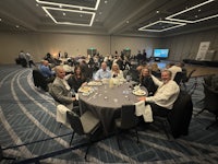 a group of people sitting around a table in a conference room