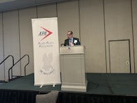 a man standing at a podium at an event